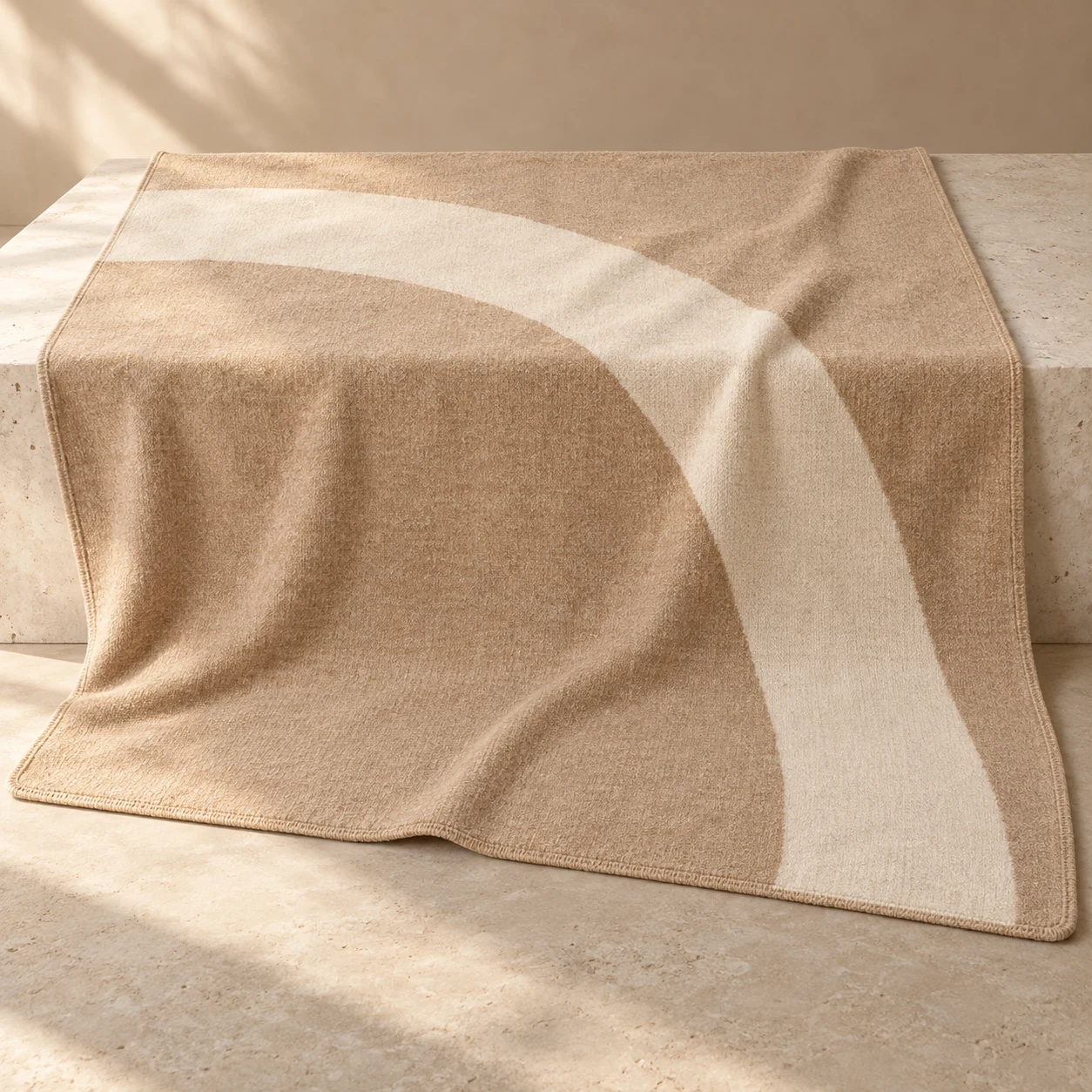 Dune Curve wool-blend throw — Sand / Cream; a sweeping cream arc across a sand field